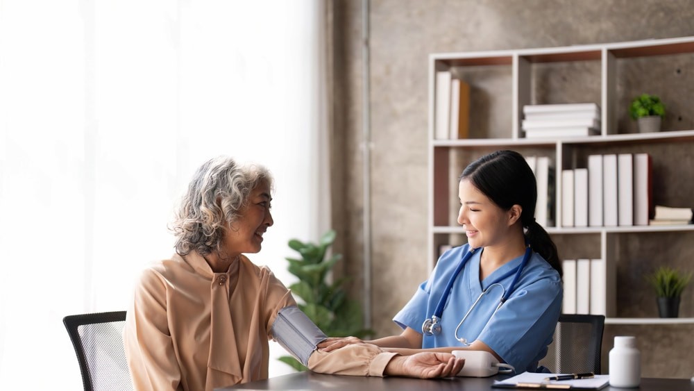 A nurse offers health advice to her elderly patient.jpg