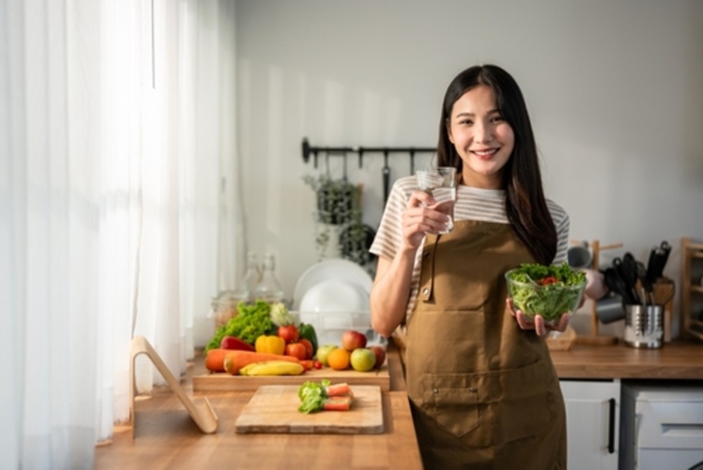 ผู้หญิงรับประทานผัก ซึ่งเป็นอาหารที่มีพรีไบโอติกส์